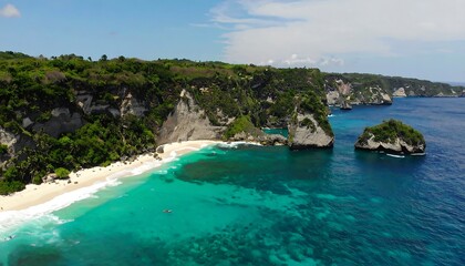 Obraz premium A breathtaking aerial view of a secluded tropical beach with turquoise waters, dramatic cliffs, and lush vegetation.