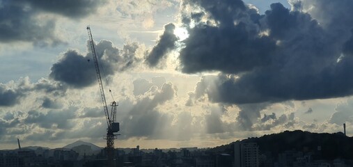 Construction Crane Against Dramatic Sky with Sunbeams