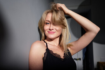 Fototapeta premium Blonde woman enjoys relaxed moment in sunshine, showcasing confidence and happiness in casual wear.