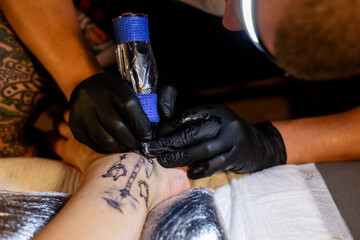 Tattoo artist carefully working on a client’s leg design under focused light. Concept of precision, artistry, creativity, and modern body art in a professional tattoo studio