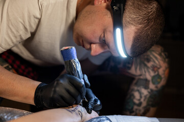 Tattoo artist carefully working on a client’s leg design under focused light. Concept of precision, artistry, creativity, and modern body art in a professional tattoo studio