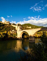 Fototapeta premium Ancient Stone Bridge River Valley Autumn Sun