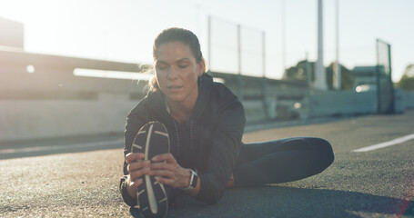 Fitness, woman and stretching legs on road for wellness, health or exercise preparation in city. Sports, runner and warm up hamstring muscle on street for flexibility, challenge or practice outdoor