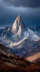 Dramatic mountain peak piercing a stormy sky
