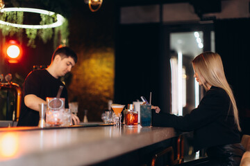 Young Woman Enjoying a Drink at a Contemporary Styled Bar Counter