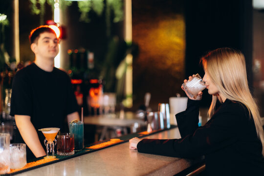 Young Woman Enjoying a Drink at a Modern Urban Bar