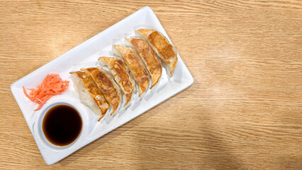 Japanese Gyoza with Dipping Sauce and Pickled Ginger on White Plate