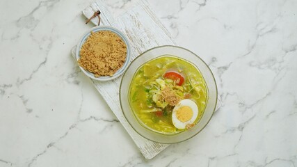 Soto Lamongan with koya in a bowl with egg. Selective focus