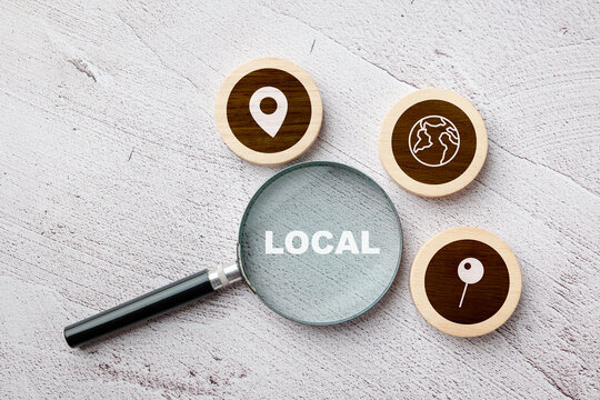 Magnifying glass focusing on the word local with map icons around, concept of local business visibility, SEO, and search engine optimization strategy