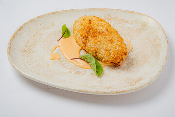 A beautifully presented dish with crispy batter on rich sauce, elegantly garnished