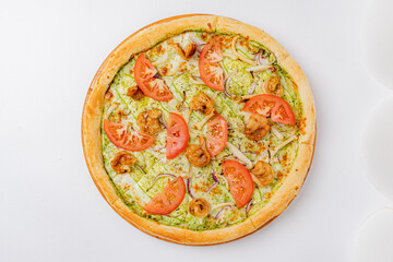 Savory shrimp and vibrant tomatoes adorn a pesto-covered pizza, perfectly baked and ready to enjoy