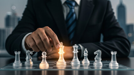Businessman playing chess, strategizing on glass board