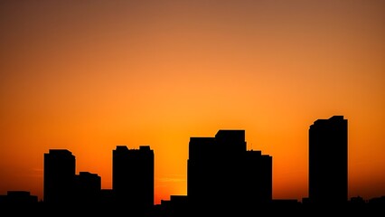 Silhouette of modern architecture against a vibrant sunset sky.