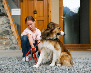 child grooming her dog outside
