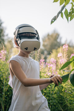Man child in virtual reality glasses explores world in nature