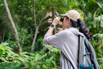 Biologist exploring tropical forest using binoculars