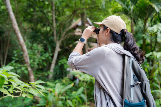 Biologist exploring tropical forest using binoculars