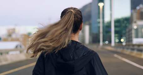 Obraz premium Back view, run and woman in city for exercise, cardio health and wellness outdoor. Race, marathon or endurance training with female runner on urban street for sport, workout and fitness on bridge
