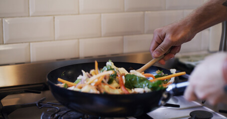 Cooking, hands and pan with meal, kitchen or mixing healthy food in home, ingredients and nutrition. Preparing, dinner and person with culinary skills, vegetables and recipe for cuisine in house