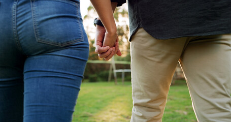 Holding hands, back and couple in garden for connection, trust and marriage with bonding outdoor. People, love and care with support, commitment and walking date in nature for healthy relationship