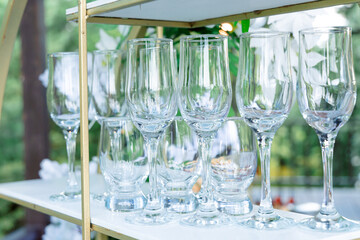 Elegant champagne glasses are carefully placed on the table, reflecting the sunlight. They create an atmosphere of celebration and elegance, perfect for wedding decor.