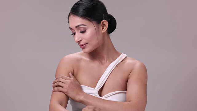 A close-up portrait of a smiling Indian woman, her face radiating warmth and joy, set against a neutral grey background. - Powered by Adobe