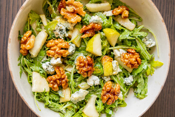 healthy fall salad with arugula pear cheese and candied walnuts