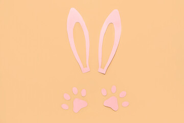 Paper bunny ears and paws on beige background