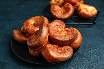 Plate with tasty Yorkshire pudding on blue background