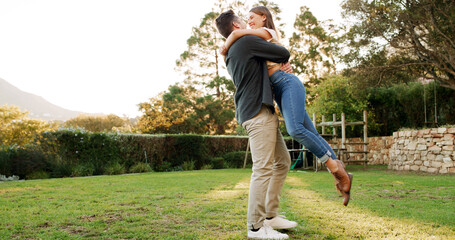 Couple, lift and hug with care in garden, connection or energy for love, trust and outdoor with romance. Marriage, excited and healthy relationship with man carrying woman for bonding in nature
