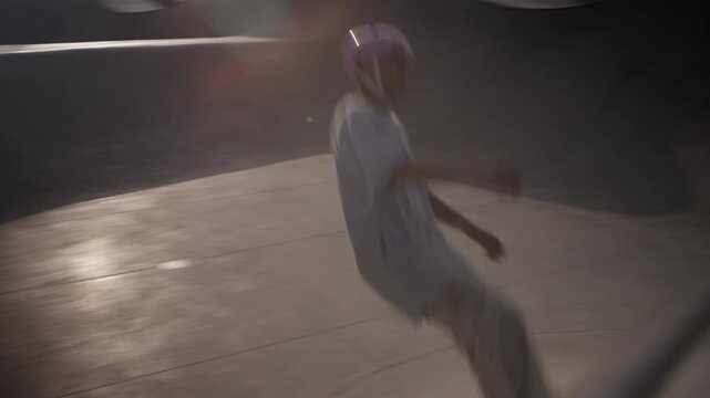 Rollerblader in helmet skates in empty stone bowl near bridge