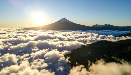 Majestic mountain peak piercing through an ocean of clouds at golden sunrise glow