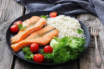 baked salmon steaks with rice, lettuce, tomatoes