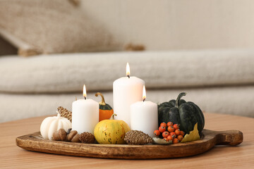 Wooden board with burning candles and natural forest decor on table