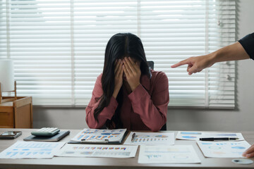 Manager scolding employee for bad results in office meeting