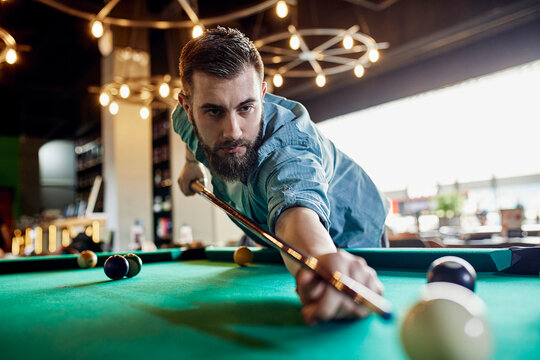 Porrait of focused man playing billiards
