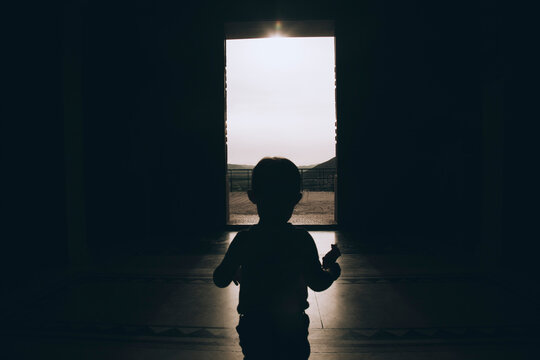 Bosnia and Herzegovina, Trebinje, silhouette of little boy walking to exit of a house