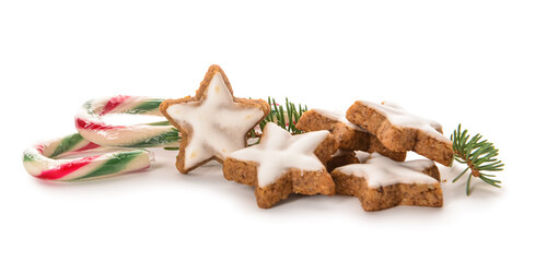 Composition with delicious stars shaped Christmas cookies, candy canes and fir tree branch on white background