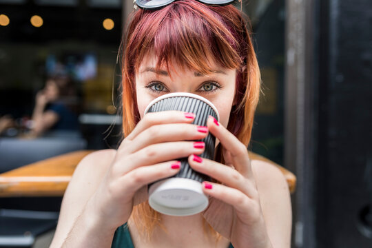 Woman drinking coffee in disposable cup