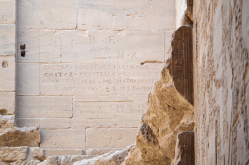 View of ancient inscriptions are etched into weathered temple walls, a timeless testament to history's enduring mark, Philae Temple, Luxor Governorate, Egypt.