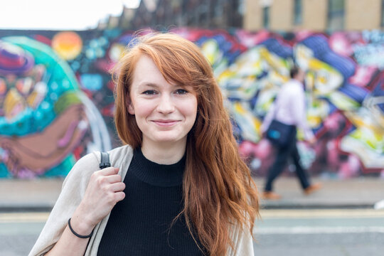 Young redhead woman smiling at street