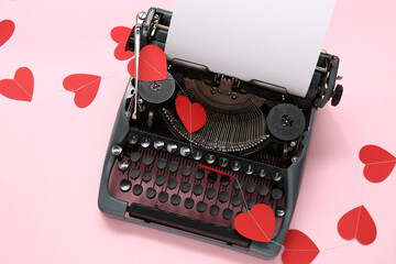Vintage typewriter and paper hearts for Valentine's day on pink background