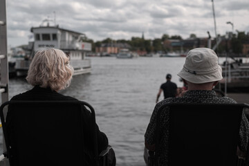 Fototapeta premium An elderly couple looking back at the horizon over the river