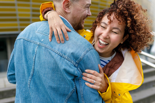 Happy woman with curly hair embracing man