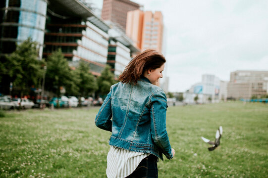 Germany, Berlin, Rear view of young woman wearing denim jacket
