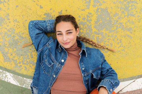 Woman with hand behind head lying on sports court