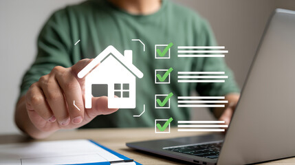 Person holding a house icon with a checklist and laptop in the background