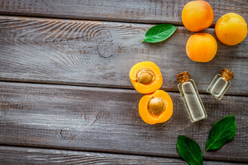 Fruit aroma oil. Apricot kernel oil on dark wooden background top view frame copy space