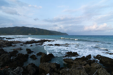 Obraz premium Dramatic seascape of the Pacific Ocean crashing against a rugged, rocky coast in Taiwan. A powerful and majestic concept of nature's raw power, wild beauty, and resilience.