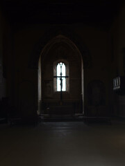Fototapeta premium Light shining through window illuminating crucifix in Sant'Agostino Church, Montalcino, Tuscany, Italy